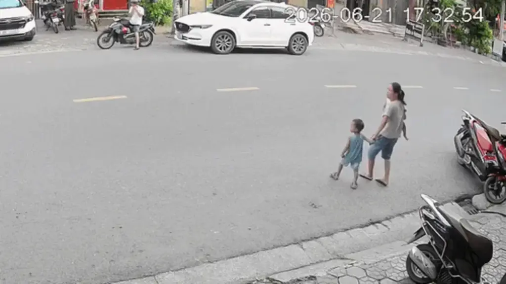 Tránh em bé chạy sang đường, người đi xe máy trượt ngã