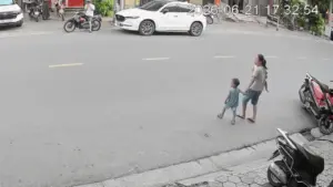 Tránh em bé chạy sang đường, người đi xe máy trượt ngã